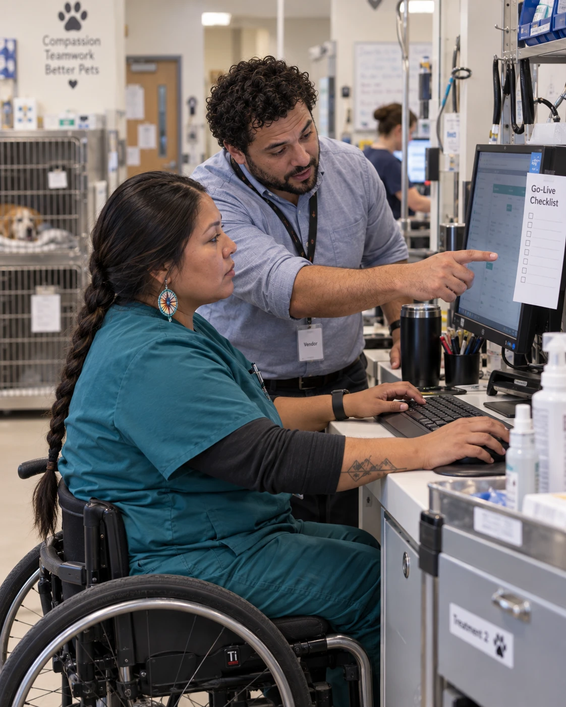 Veterinary technician learning new practice management software from a trainer during a go-live week