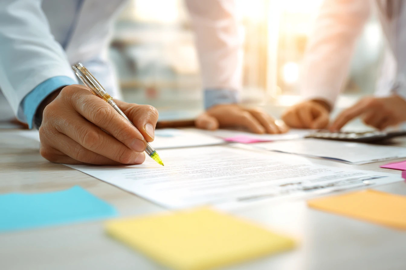 Practice owner and manager reviewing a software contract at a conference table with uplift clause highlighted and text blurred