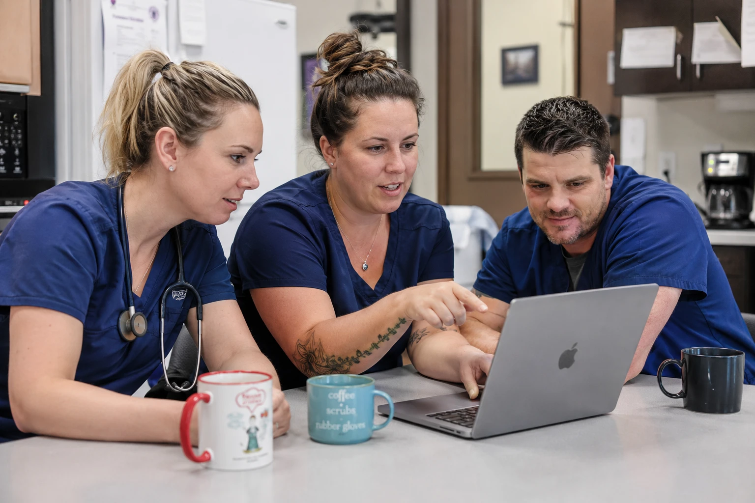 Veterinary team gathered around a laptop evaluating client communication software during a product demo